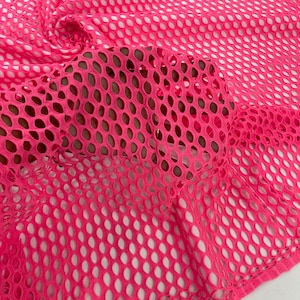 May include: Pink mesh fabric with a diamond pattern. The fabric is soft and stretchy.