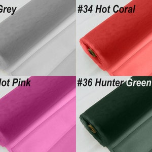 May include: Four rolls of tulle fabric in different colours: grey, hot coral, hot pink, and hunter green. The fabric is rolled up and the ends are visible.
