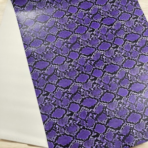 May include: Purple snakeskin patterned fabric with a white backing.