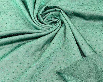 May include: A close-up of a green fabric with a textured surface. The fabric has a subtle sheen and a pattern of small, raised dots.