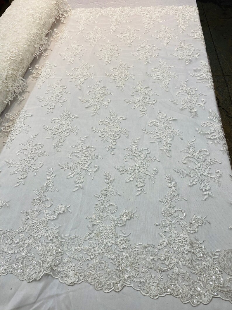 May include: White beaded lace fabric with a floral pattern. The lace has a delicate, intricate design with small, white beads.