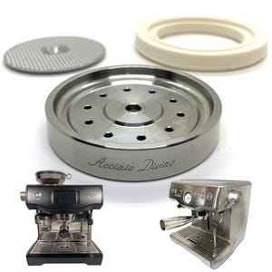May include: Stainless steel espresso machine components, including a portafilter, filter basket, and a group head with the text "Acciaio Divino". Two espresso machines are also visible.