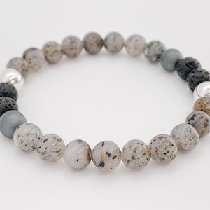 May include: A grey, black and silver beaded bracelet with a mix of round and irregular shaped beads.