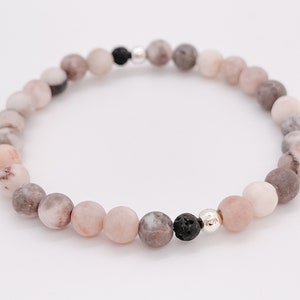 May include: A pink and grey gemstone bracelet with black lava beads and silver accents.