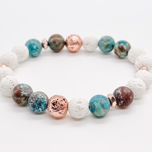 May include: A bracelet made with white, brown, and blue beads. The bracelet has a mix of round and irregular shaped beads.