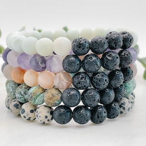Peut inclure: Un ensemble de six bracelets faits de perles de différentes couleurs. Les bracelets sont faits de perles d'améthyste, d'agate, de turquoise, de roche volcanique et de jaspe dalmatien.