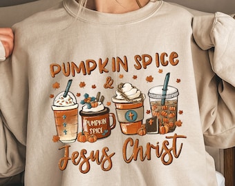 May include: A beige sweatshirt with a graphic design of fall-themed coffee cups and the text "Pumpkin Spice & Jesus Christ".