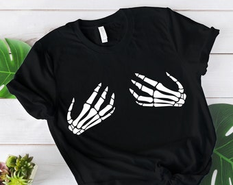 May include: Black t-shirt with a white skeleton hand graphic on the front. The hands are in a hugging position.