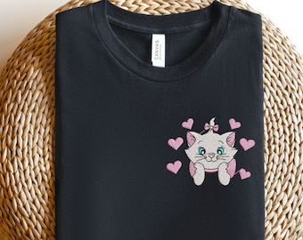 May include: Black t-shirt with a pink embroidered image of a cat with hearts. The cat has a pink bow in its hair.