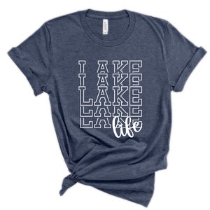 May include: A navy blue t-shirt with the text "I lake life" printed in white. The text is stacked vertically with the word "lake" repeated four times.