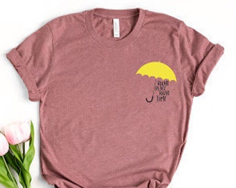 May include: A maroon t-shirt with a yellow umbrella graphic and the text "Sigh, I'm not fine" printed on the front.