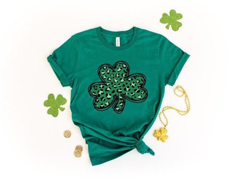 May include: A green t-shirt with a black and green leopard print shamrock design.