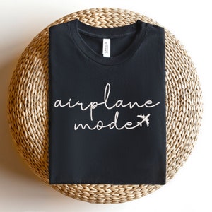 May include: Black t-shirt with white text that says "airplane mode" and a small airplane icon.