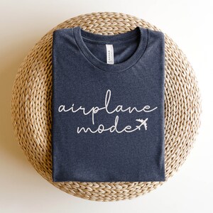 May include: A dark grey t-shirt with the text "airplane mode" in white lettering and a small airplane icon.