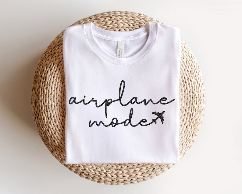 May include: White t-shirt with black text that says "airplane mode" with a small airplane icon.