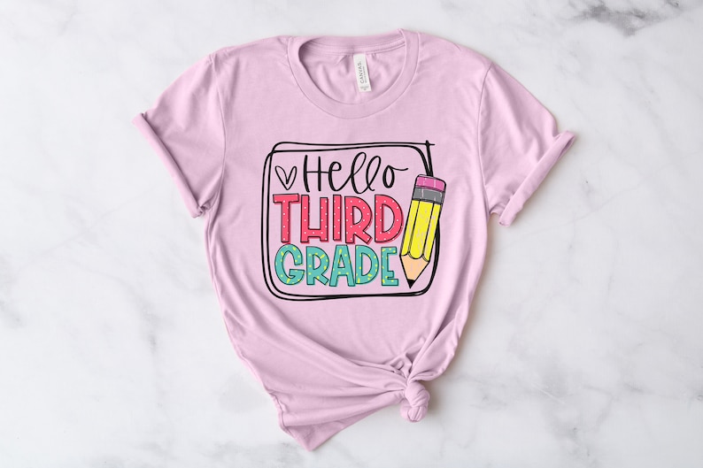 May include: Pink t-shirt with a graphic design that says "Hello Third Grade" with a pencil illustration.
