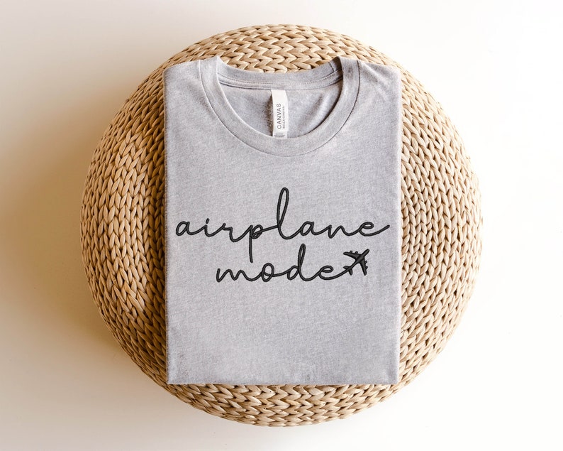 May include: A grey t-shirt with the text "airplane mode" and a small aeroplane graphic printed on it.