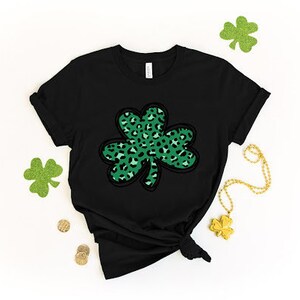 May include: Black t-shirt with a green and black leopard print shamrock design.