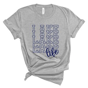 May include: Gray t-shirt with a navy blue graphic that says "I  LAKE life" with the word "LAKE" repeated multiple times.
