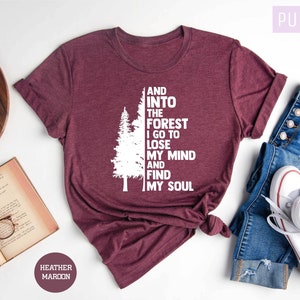 May include: Heather maroon t-shirt with a white graphic of a pine tree and the text "And into the forest I go to lose my mind and find my soul".