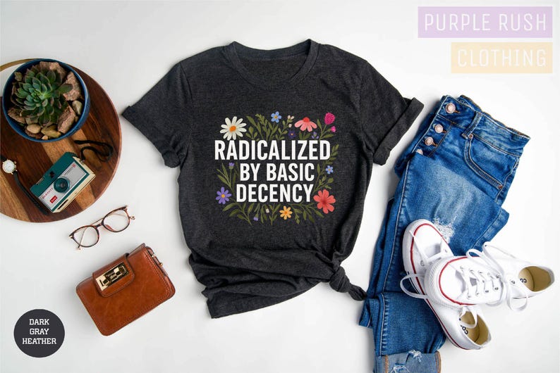 a casual outfit consisting of a black t-shirt with a floral design, a pair of blue jeans, white sneakers, and a pair of glasses. The outfit is arranged on a white background, with various accessories such as a wallet, a camera, and a potted plant.