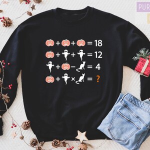 a black sweater with the numbers for halloween on it