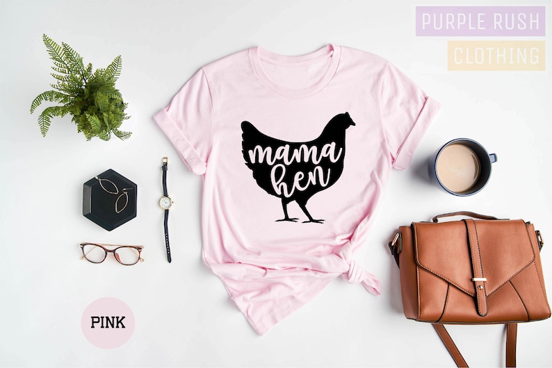 May include: A pink t-shirt with a black silhouette of a chicken and the text "mama hen" printed on the front.