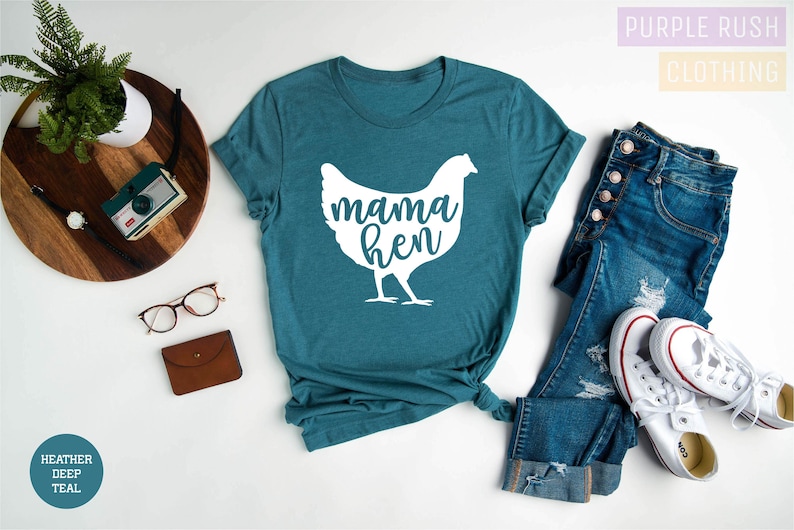 May include: A teal blue t-shirt with a white silhouette of a chicken and the text "mama hen".