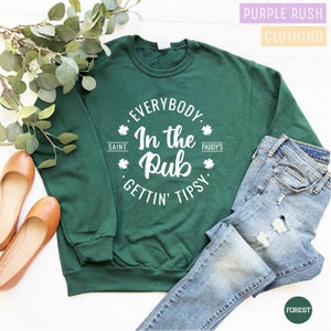 May include: Green sweatshirt with a white circle graphic that says "Everybody. In the Pub. Gettin' Tipsy." with shamrock symbols and the words "Saint" and "Paddy's" on either side of the graphic.