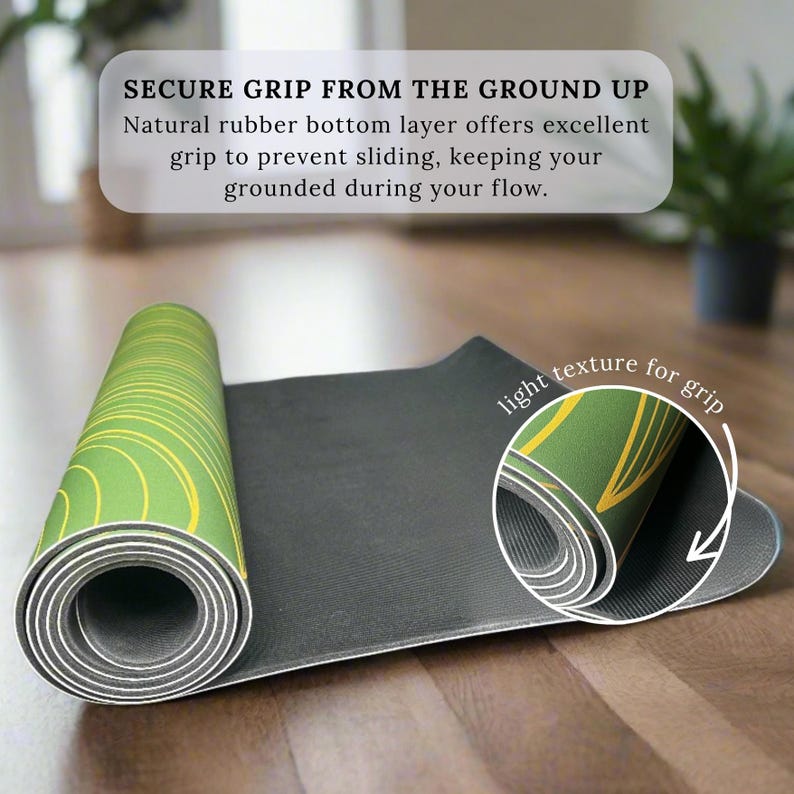 May include: A partially unrolled yoga mat with a green and yellow circular design. The mat has a black underside and a light texture for grip. Text on the image reads "SECURE GRIP FROM THE GROUND UP".
