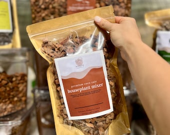 May include: A clear plastic bag filled with brown coco coir, labeled "premium coco coir houseplant mixer." The label also states the product is a chunky, well-draining medium for potting houseplants and cacti. The bag is held by a hand.