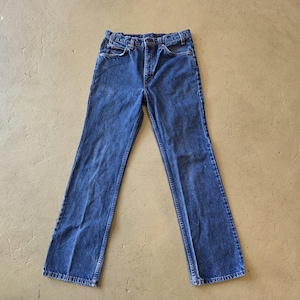 May include: A pair of dark blue denim jeans featuring a high-waisted design, a classic five-pocket construction, a metal button closure, and a zip fly. The jeans have straight legs and visible stitching along the seams and pockets.