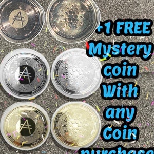 May include: Six silver and gold colored cryptocurrency coins with a black letter A and a honeycomb pattern. The text +1 FREE Mystery coin with any coin purchase is visible in the image.