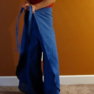 May include: A pair of blue denim wrap pants with a long sash tie. The pants are loose fitting and have a wide leg.