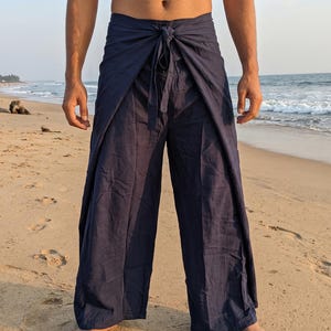 May include: Dark navy blue wrap-style trousers featuring a wide-leg silhouette and a front-tie closure at the waist. The garment is constructed with a layered fabric design that overlaps at the center, creating a distinct draped appearance.