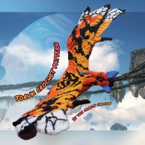 May include: A crochet Toruk pattern in orange, black, and white, with blue details. The text "TORUK CROCHET PATTERN" and "BY THE CRAFTY FALCON" are visible. The wings are spread, set against a fantasy landscape background.