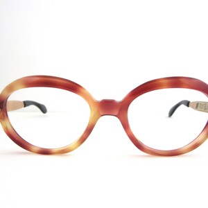 May include: A pair of round, tortoiseshell eyeglasses with gold accents on the temples.