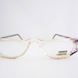 Puede incluir: Gafas de plástico transparente con detalles morados y el texto "DIMENSION" impreso en la lente derecha.
