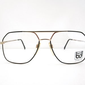 May include: Black and gold aviator style eyeglasses with a BerDei ITALY logo on the right lens.