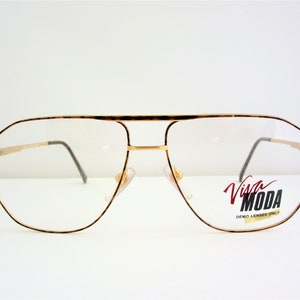 May include: Gold-tone aviator eyeglasses with a tortoiseshell frame and clear lenses. The glasses have a Viva Moda label on the right lens that says "Demo Lenses Only".