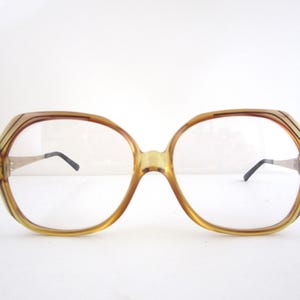 May include: A pair of brown plastic eyeglasses with a square frame and clear lenses.