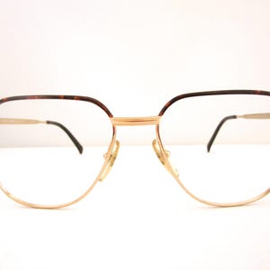 Puede incluir: Gafas de metal doradas con detalles en carey marrón en el marco.