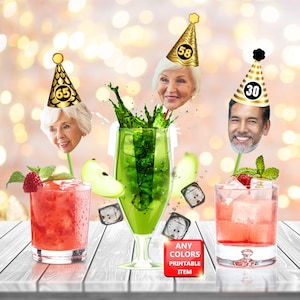 May include: Three green and gold party hats with numbers 30, 58, and 65 on them. Each hat has a face printed on it. The hats are on sticks and are in front of three different drinks. The drinks are in clear glasses and are on a wooden table. The text "ANY COLORS PRINTABLE ITEM" is on a red square.
