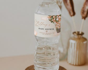 Op de afbeelding: Een doorzichtige plastic waterfles met een wit etiket met een teddybeer in een heteluchtballon, de tekst Bethany's BABY SHOWER, een hartje en de tekst THANK YOU FOR MAKING THIS DAY SO SPECIAL in bruine en groene tinten.