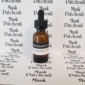 May include: A brown glass bottle with a black dropper top and a white label that reads "FRAGRANCE OIL Patchouli Musk". The bottle is surrounded by white labels with the text "Musk Patchouli" repeated multiple times.