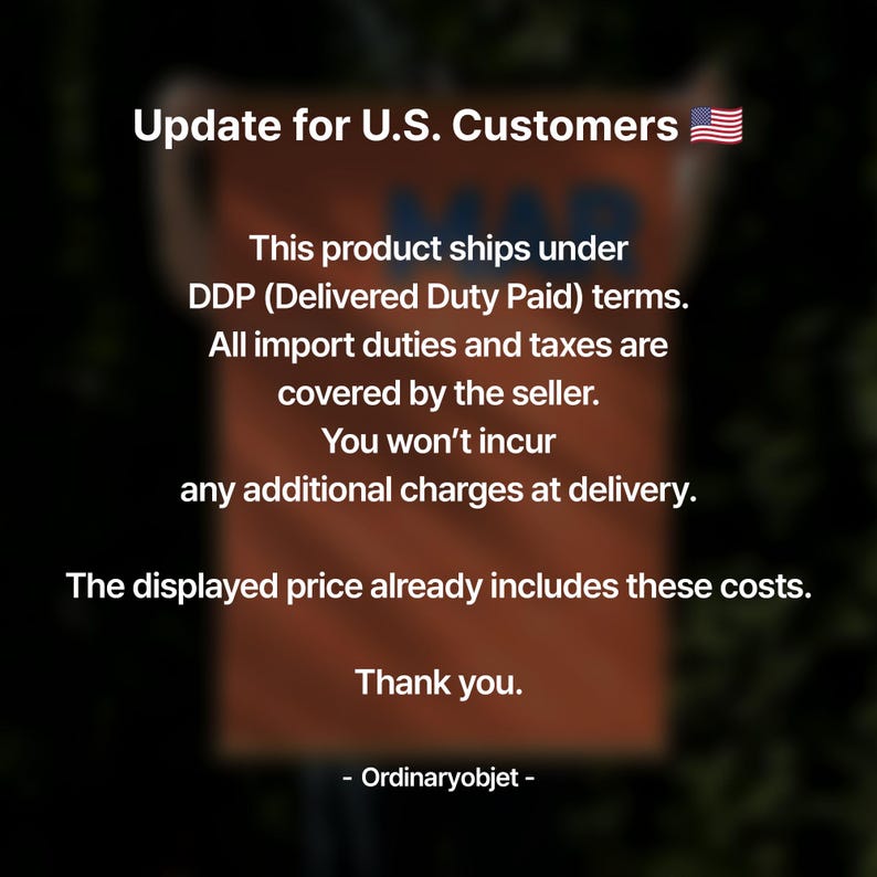 May include: An orange sign with the text "Update for U.S. Customers" and a small American flag. The sign provides information about shipping and import duties, stating that the displayed price includes all costs.