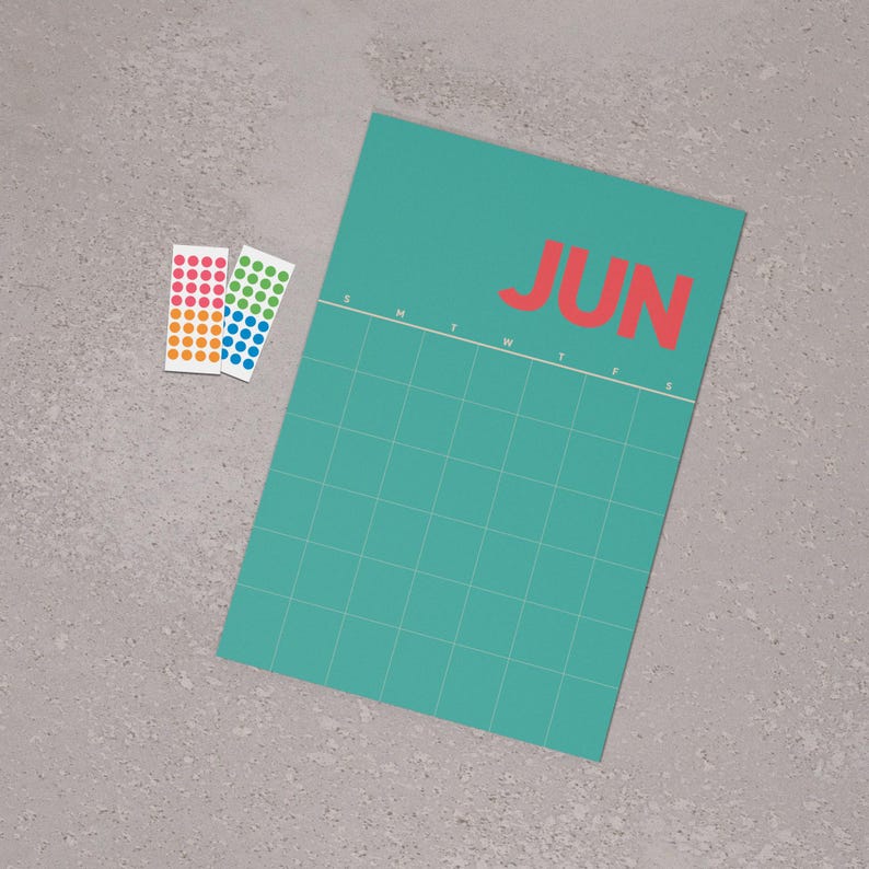 May include: A teal June calendar with a grid layout and the word "JUN" in red. Two sticker sheets with colourful dots are next to the calendar. The calendar has a simple, modern design.