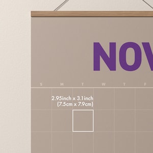 May include: A beige wall calendar with the month of November in large purple letters. The calendar has a wooden hanger and includes the text "2.95inch x 3.1 inch (7.5cm x 7.9cm)".