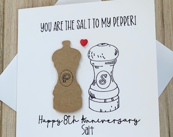 Könnte beinhalten: Eine weiße Karte mit einer Schwarzweißillustration eines Salz- und Pfefferstreuers. Die Karte sagt "You are the salt to my pepper!" und "Happy 8th Anniversary Salt". Zwischen dem Salz- und Pfefferstreuer befindet sich ein rotes Herz.