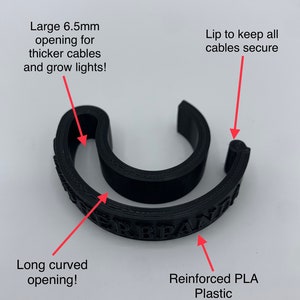 May include: Black cable organizer made of reinforced PLA plastic. It has a large 6.5 mm opening for thicker cables and a long curved opening. The lip helps keep cables secure.